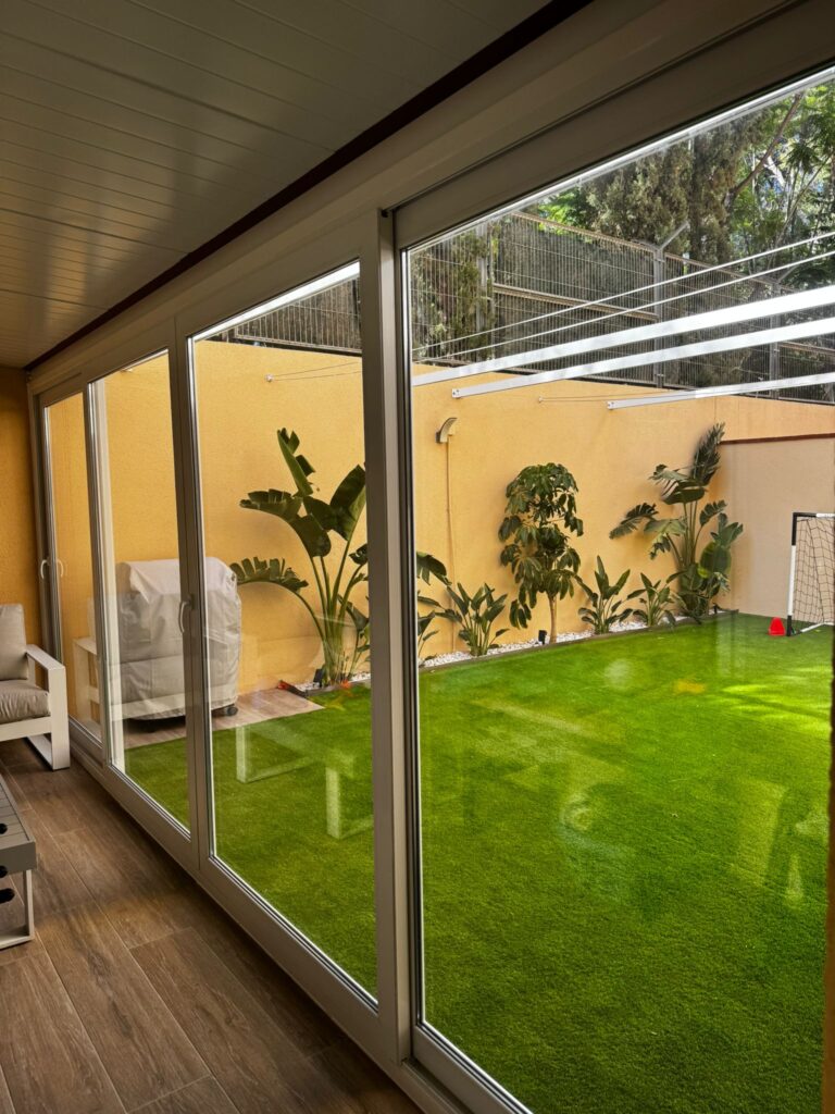 Ventana corredera PVC blanca cuatro hojas con persianas vista exterior